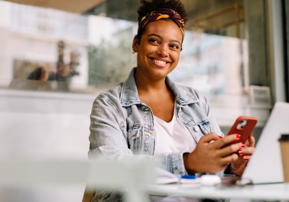 a woman smiling while holding a phone