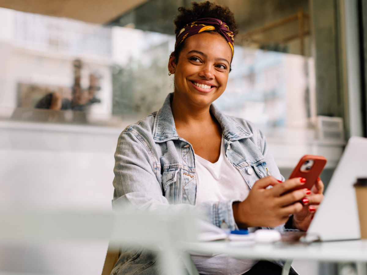 a woman smiling while holding a phone
