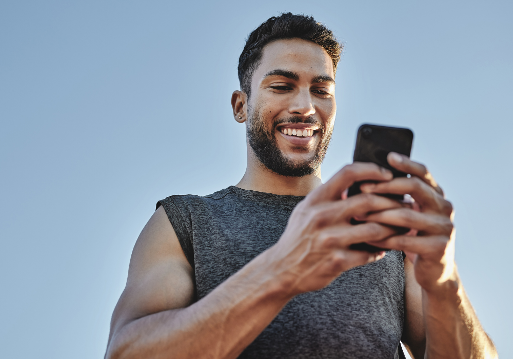 a man smiling while looking at his phone