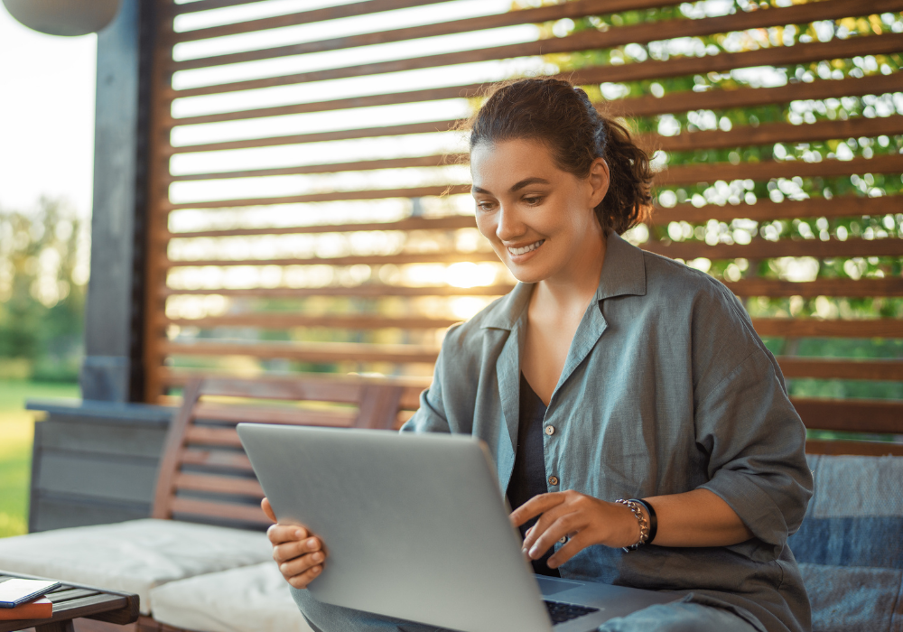a woman sitting on a bench with a laptop