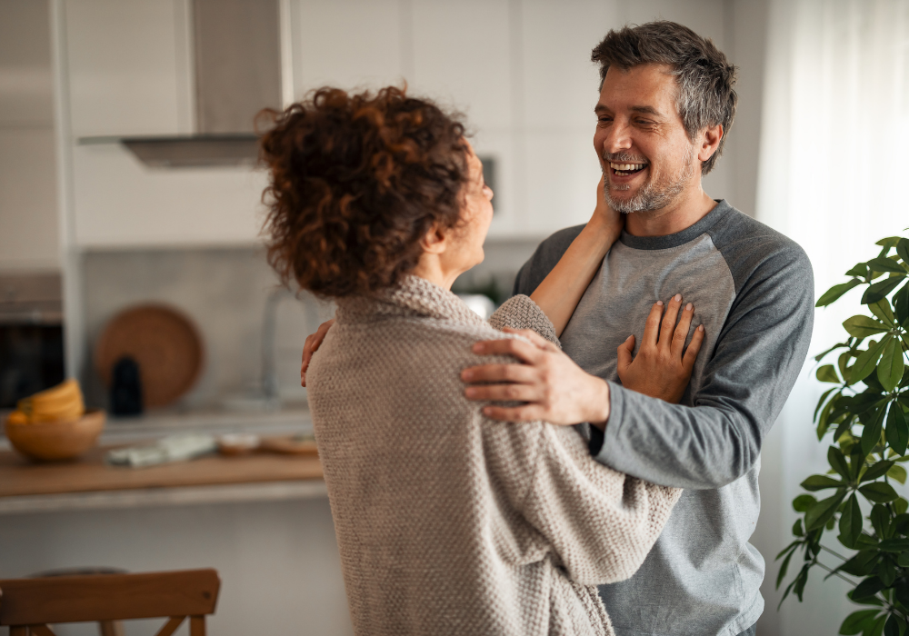 a man and woman hugging in a kitchen