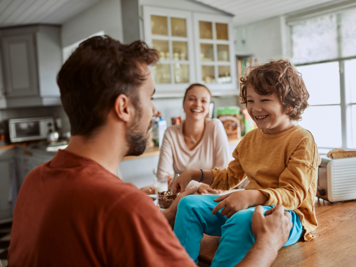 a man and woman sitting at a table with a child